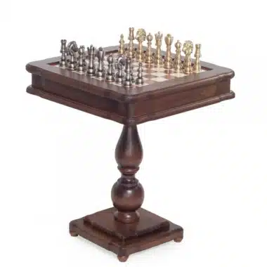 Mesa de ajedrez sobre pie de madera con juego de ajedrez en latón dorado y plateado