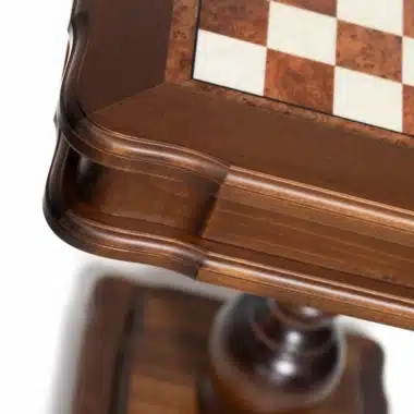 Detalle de la esquina tallada de la mesa de ajedrez y la pata de madera torneada