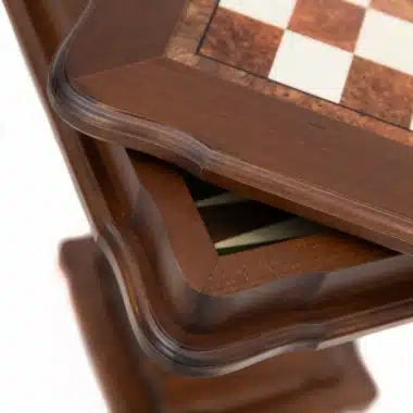 Primer plano del borde tallado del tablero y el pie de la mesa