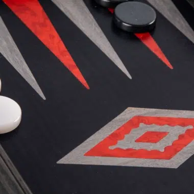 Backgammon de madera de roble negro y plateado, primer plano de los triángulos rojos y grises