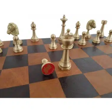 Rey dorado de latón macizo con placa roja grabada colocada sobre el tablero de cuero