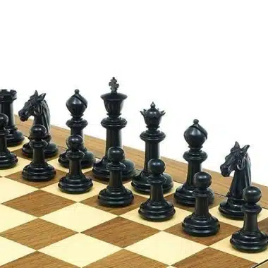 Piezas de ajedrez negras de ébano alineadas sobre el tablero de madera