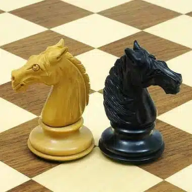 Caballos de madera de ébano claro y oscuro colocados sobre el tablero de arce y nogal