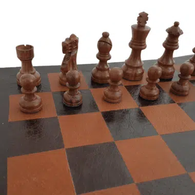 Piezas de madera de rosa dorada en primer plano sobre el tablero de cuero, torre, caballo y alfil