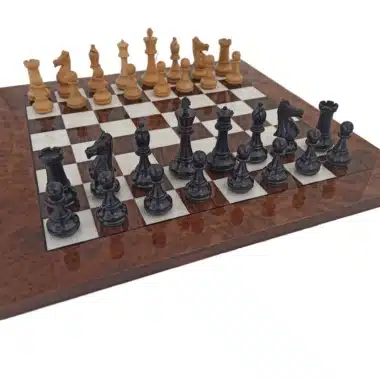Juego de ajedrez completo en madera de ébano sobre tablero de raíz de nogal, vista frontal