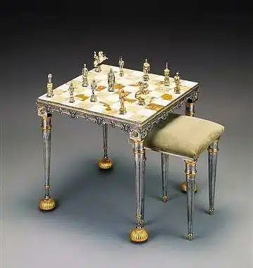 Mesa de ajedrez cuadrada en ónix con piezas de bronce dorado y plateado, y taburete a juego