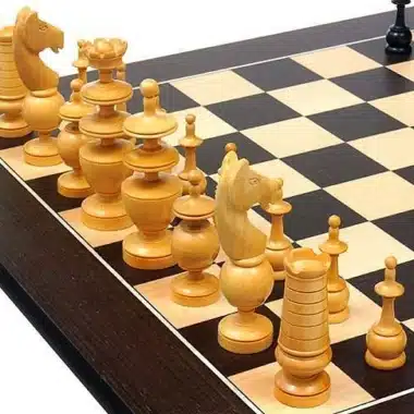 Piezas claras del juego Palais Français alineadas sobre el tablero de wengué