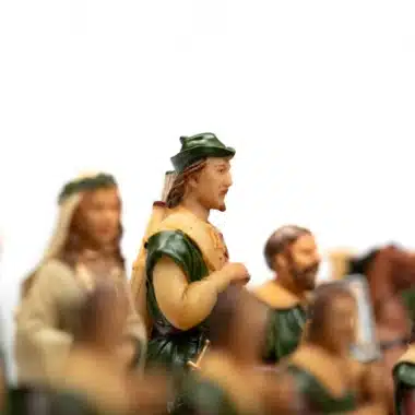 Piezas Robin Hood y dama detalladas frente a un caballo desenfocado