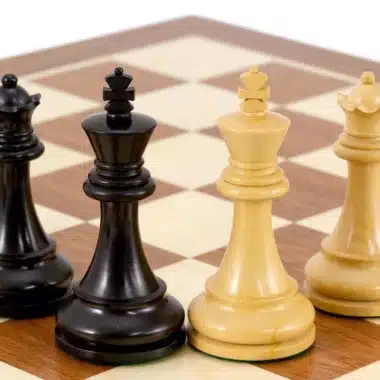 Reyes y damas negros y blancos alineados sobre el tablero de arce y caoba
