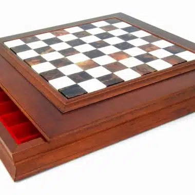 Caja de almacenamiento abierta con compartimentos rojos bajo el tablero de ajedrez