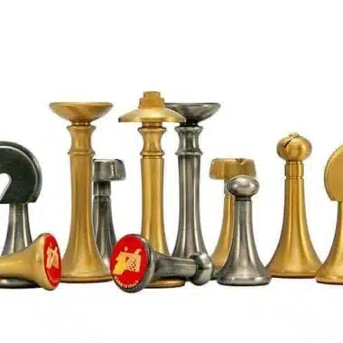 Piezas de ajedrez de latón, bases con fieltro rojo y medallones decorativos