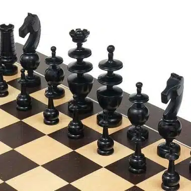 Piezas negras ebonizadas alineadas sobre el tablero, vista detallada de caballos y dama