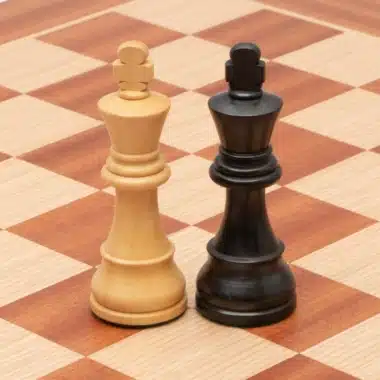 Reyes claro y negro Classic XIX frente a frente sobre el tablero de caoba