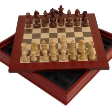 Juego de ajedrez completo con piezas de madera colocadas sobre el tablero abierto en caja