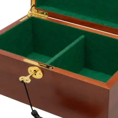 Detalle de la cerradura dorada y la llave de la caja de almacenamiento de caoba