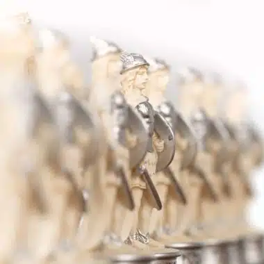 Fila de peones guerreros con casco y escudo en primer plano