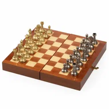Tablero plegable visto de lado, piezas doradas y plateadas alineadas sobre fondo abierto