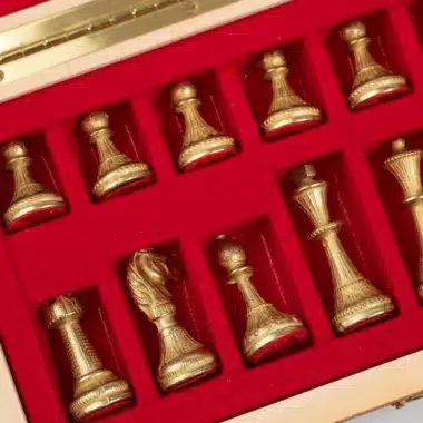 Estuche abierto mostrando las piezas doradas colocadas sobre terciopelo rojo