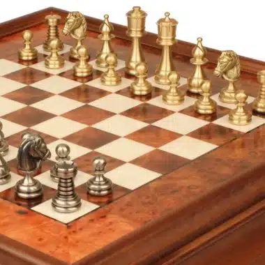 Detalle de las piezas doradas y plateadas de latón macizo sobre el tablero de madera de raíz