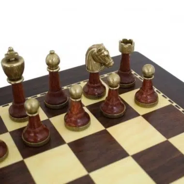 Piezas en metal dorado y burdeos, caballo y torre en primer plano sobre el tablero