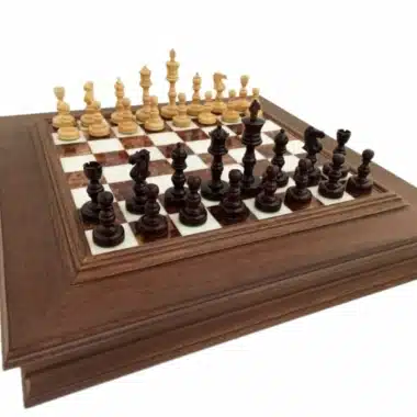 Juego de ajedrez completo con piezas de madera de rosa oscura y clara sobre tablero de madera y mármol