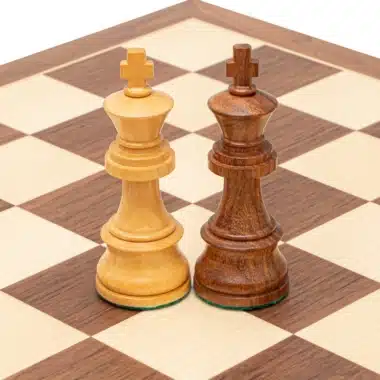 Dos reyes, claro y de madera de rosa, frente a frente en el tablero
