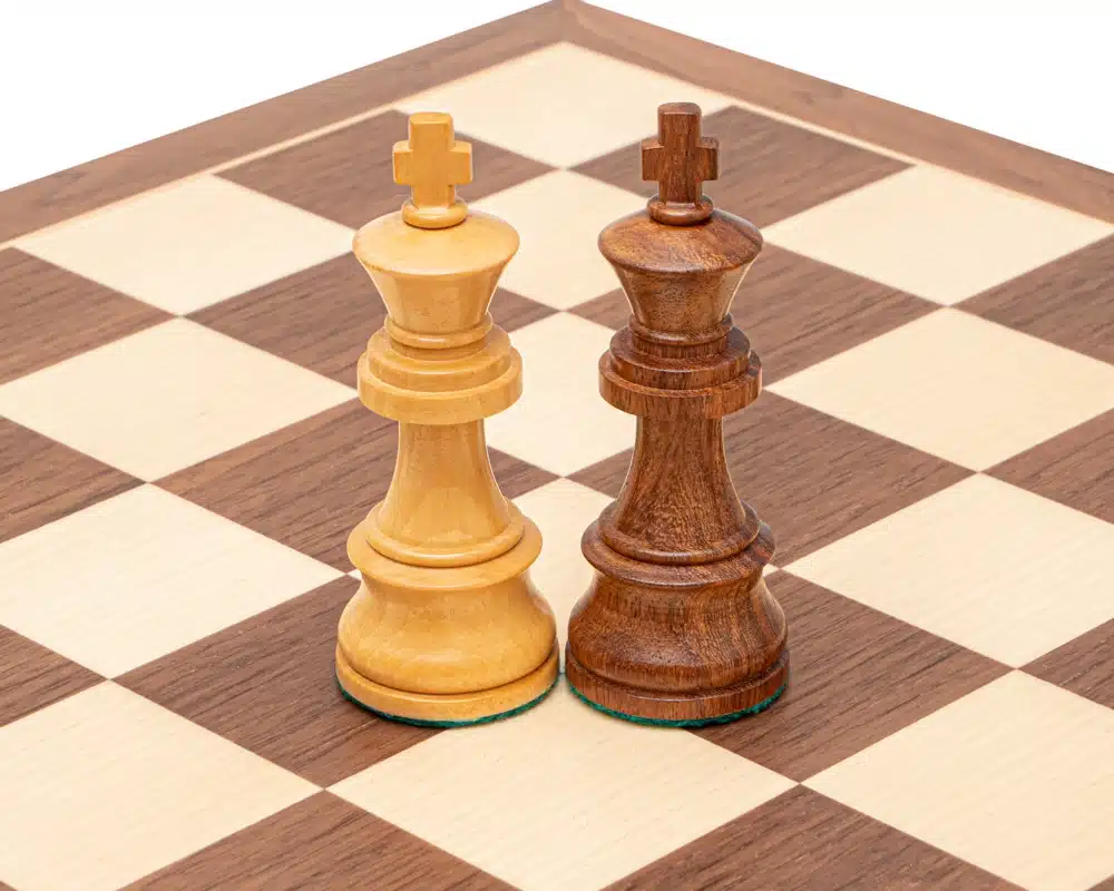 Dos reyes, claro y de madera de rosa, frente a frente en el tablero