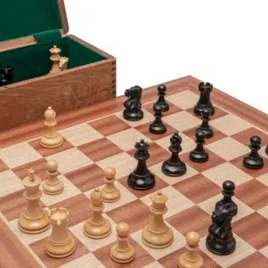 Detalle de las piezas Staunton en madera de boj colocadas sobre el tablero junto a la caja de palisandro abierta