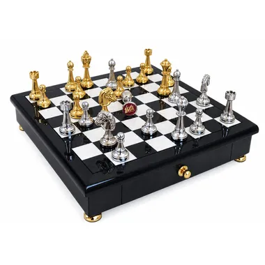 Juego de ajedrez completo bañado en oro y plata sobre tablero negro y blanco con cajón