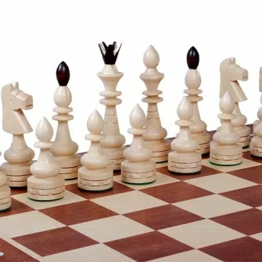 Primer plano de las piezas claras, rey, dama, alfiles y caballos sobre el tablero