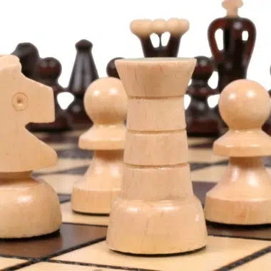 Piezas de ajedrez en madera clara y oscura, primer plano de la dama y los peones