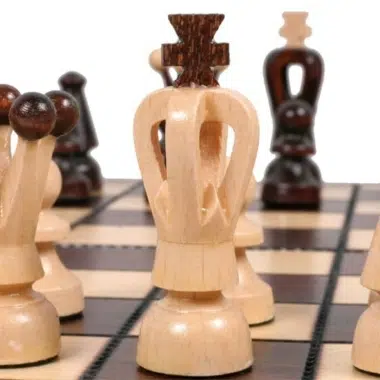 Primer plano de los reyes claro y oscuro finamente tallados frente a frente en el tablero