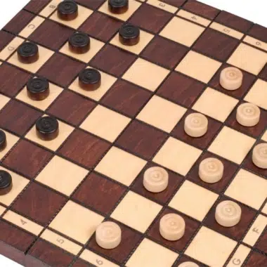 Fichas de damas claras y oscuras colocadas sobre las casillas del tablero
