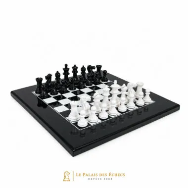 Juego de ajedrez bicolor negro y blanco, piezas en posición inicial sobre tablero lacado