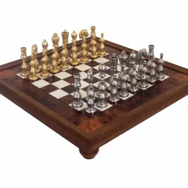 Juego de ajedrez completo con piezas chapadas en oro y plata sobre tablero con pie