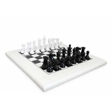 Juego de ajedrez Staunton negro y blanco colocado sobre un tablero blanco