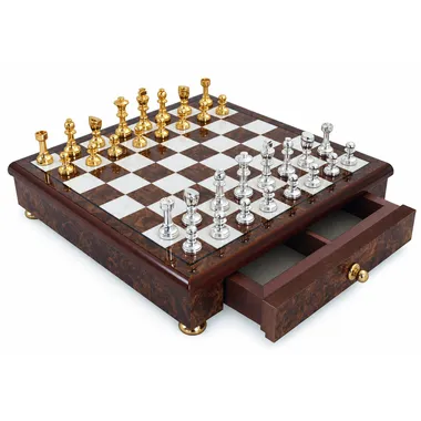 Juego de ajedrez completo Staunton dorado y plateado sobre tablero de madera con cajón abierto