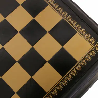 Mesa de ajedrez en madera negra, detalle del tablero y los motivos dorados