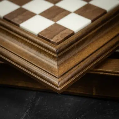 Esquina de la caja de madera mostrando las casillas de mármol y madera del tablero