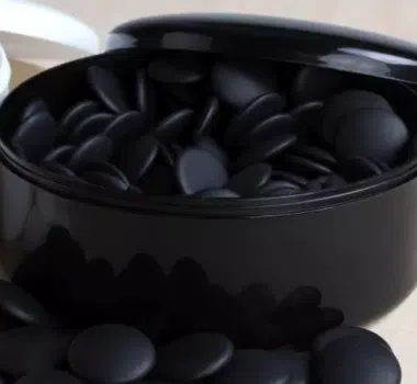 Estuche negro lleno de piedras de go de resina oscura