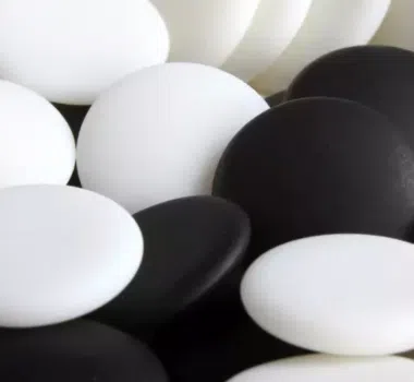 Primer plano de piedras de go blancas y negras mezcladas
