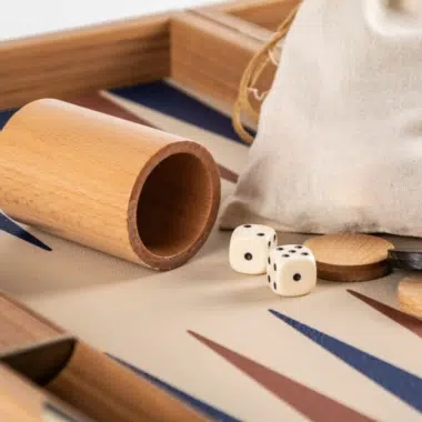 Backgammon de símil piel beige champán, detalle del cubilete de madera y la bolsa de tela