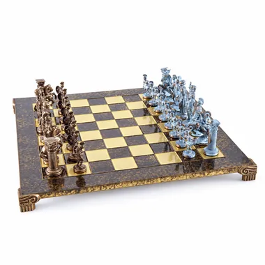 Tablero de ajedrez metálico con piezas bronce y azules enfrentadas, vista general en ángulo