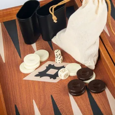 Detalle de los cubiletes de dados negros y la bolsa de tela del set