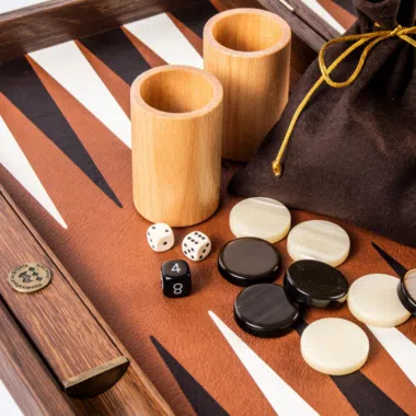 Cubiletes de madera, dados, fichas y bolsa sobre el tablero
