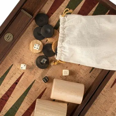 Fichas de madera de olivo, dados y bolsa de tela sobre tablero de corcho