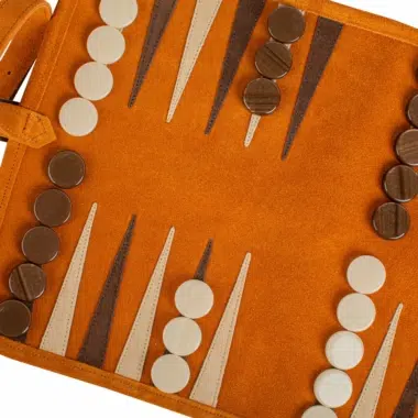 Detalle de las fichas y segmentos sobre el tablero de backgammon enrollable de ante marrón, estética armoniosa