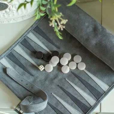 Ambiance calme autour du backgammon en daim vert forêt ouvert sur une table
