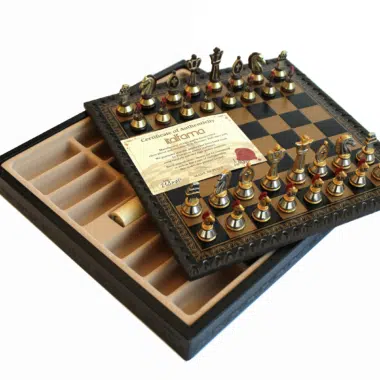 Caja de ajedrez abierta mostrando la superficie en símil cuero negro y el compartimento de almacenamiento interior para las piezas romanas