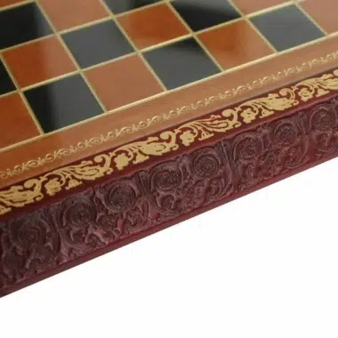 Gros plan sur les motifs arabesques en relief et la frise dorée du cadre en cuir véritable fait main en Italie